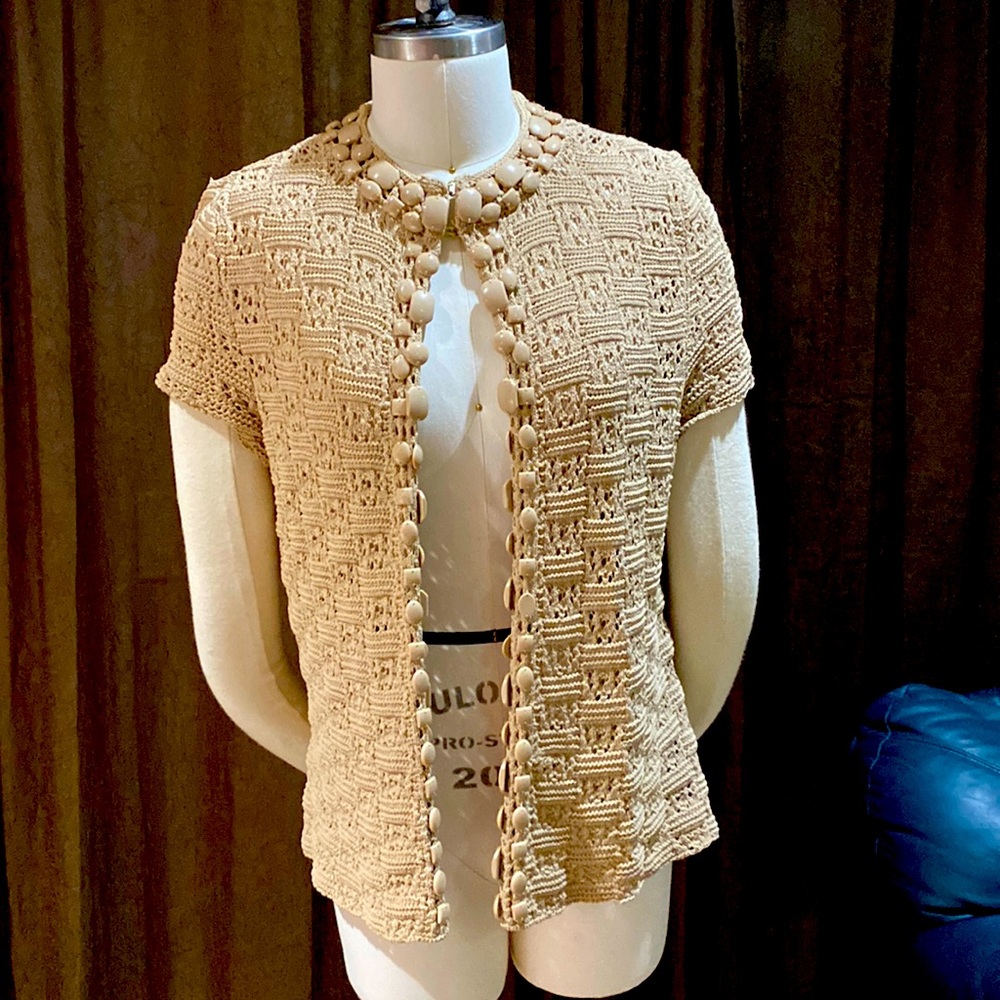 Beige sweater with beaded edge detail.